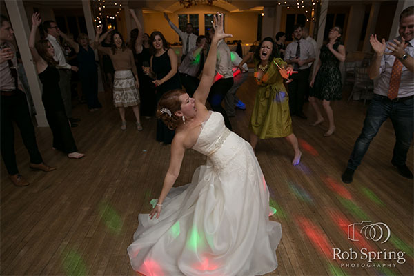 Bride dancing on dance floor with guests around by Rob Spring Photography