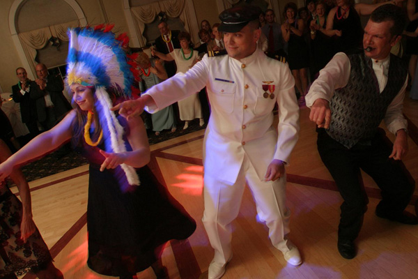 Man & woman dancing in costume at party with DJ