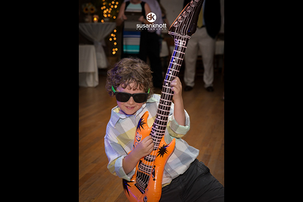 Boy playing blow up guitar at wedding reception by Susan Knott Photography