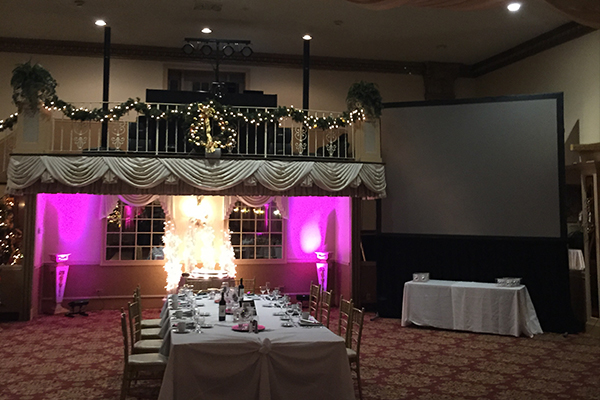 Pink up lighting and screen setup at wedding