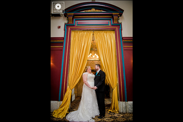 Bridge and groom wedding photo with bright yellow curtain