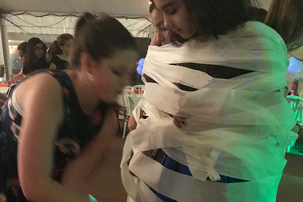 Kids playing mummy wrap game at bat mitzvah
