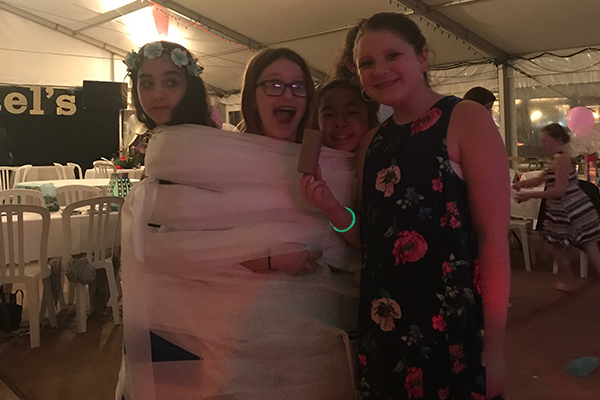 girls playing mummy wrap game at bat mitzvah