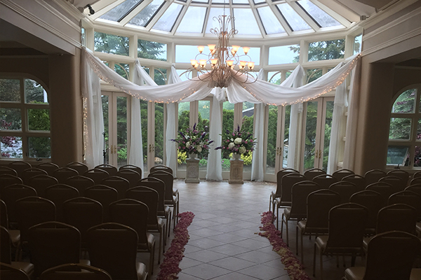 Beautiful wedding ceremony setup with white curtains and flowers