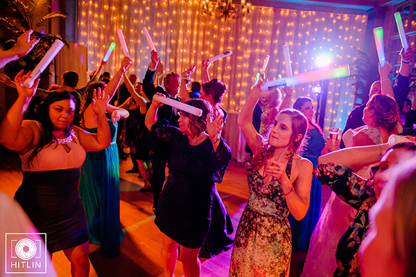 Wedding guests dancing with glow sticks on dance floor