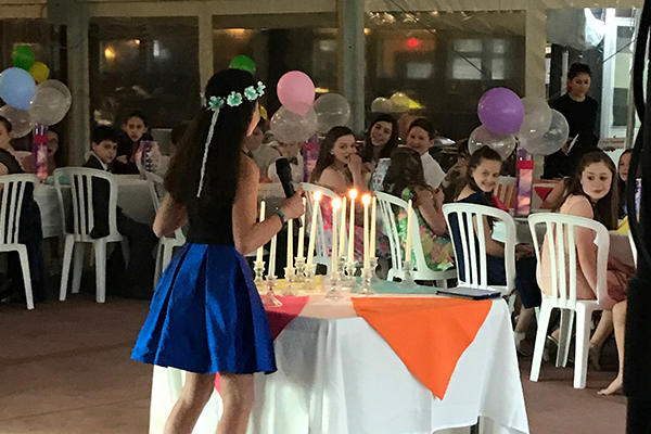 Girl at bat mitzvah with flower crown and candles