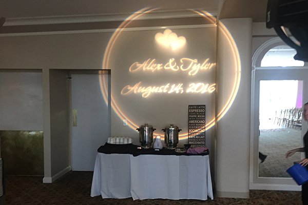 Monogram lighting on wall at wedding reception with bride and groom names and date
