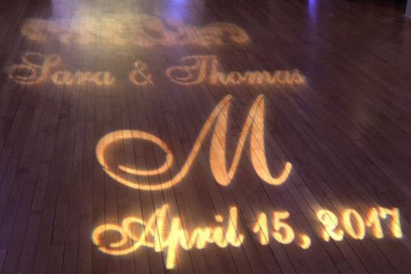 Monogram lighting on dance floor at wedding reception with bride and groom names and date