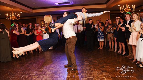 Fun swing dancing on dance floor at wedding reception